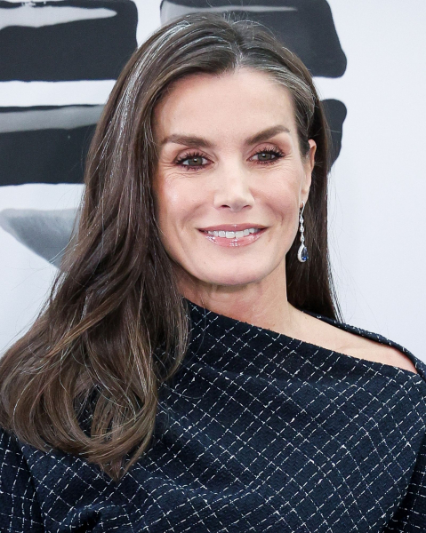 Queen Letizia of Spain smiling in a black and white dress